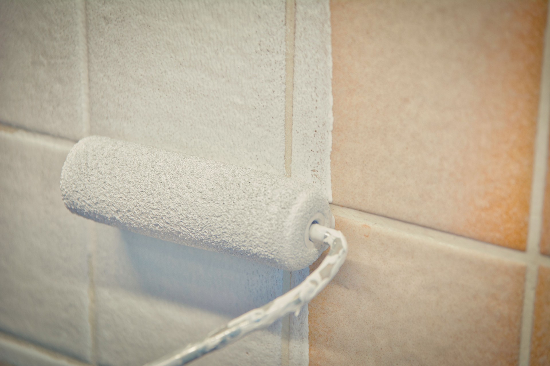 Painting old tiles in the kitchen or bathroom white with a small roller and two component paint.